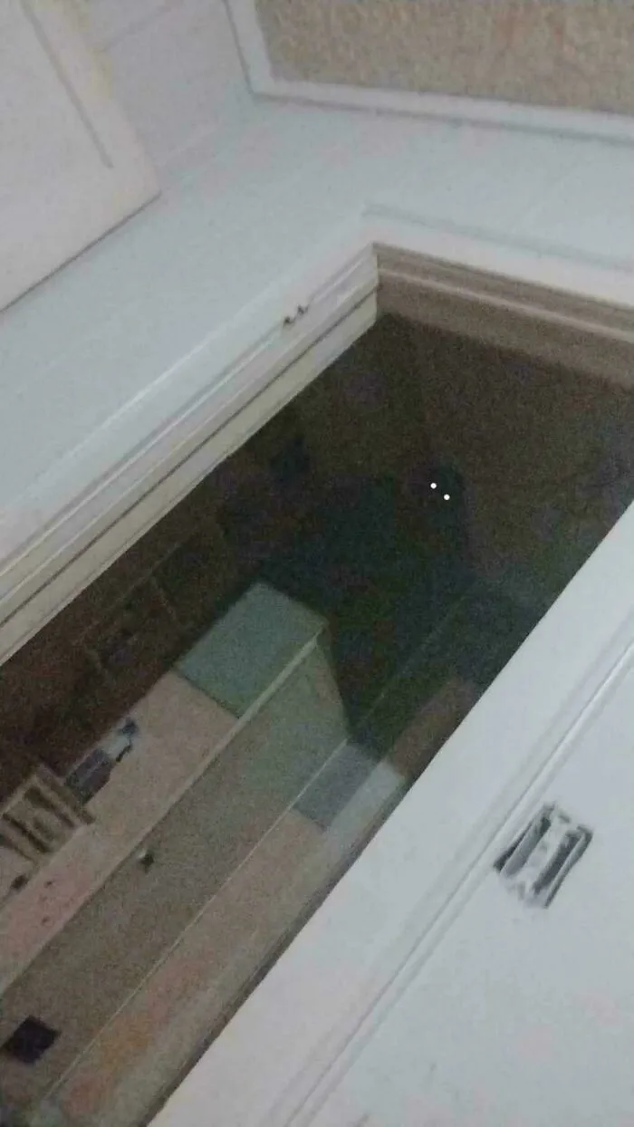 Creepy photos showing glowing eyes staring from a dark opening in a ceiling hatch.