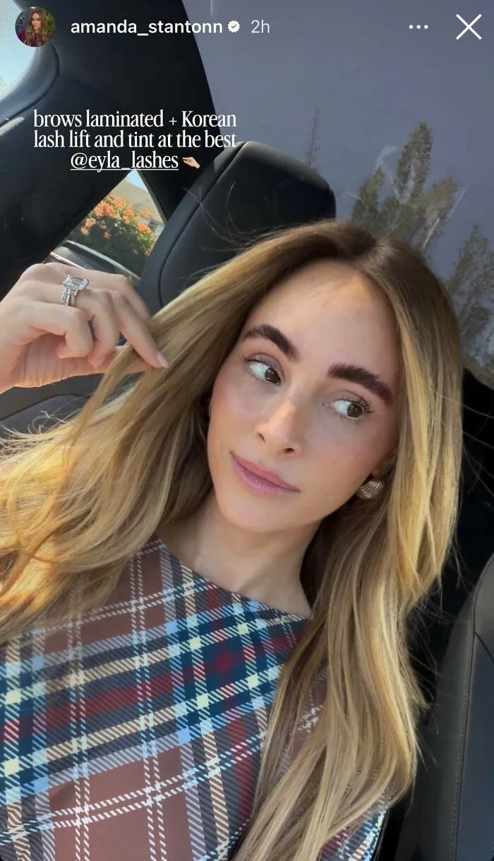 Woman with laminated brows and Korean lash lift in car selfie