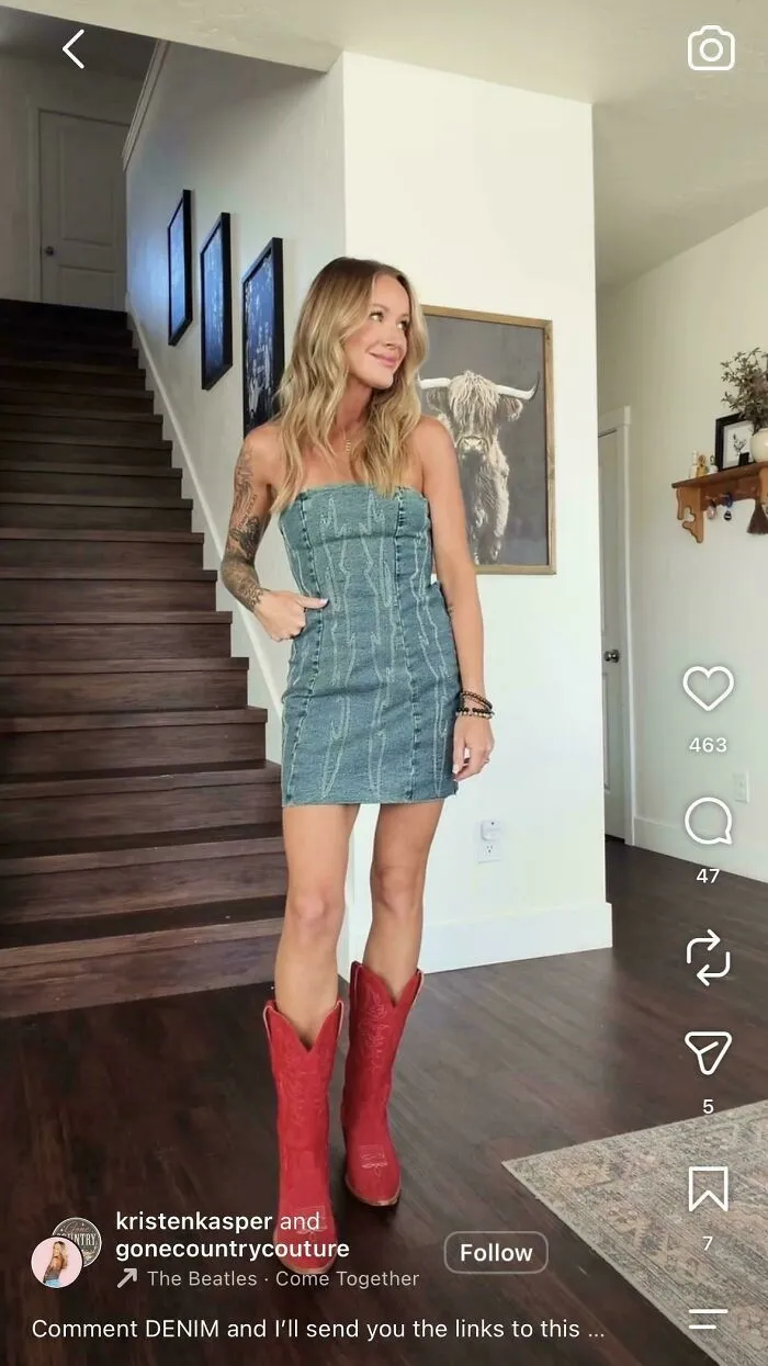 Woman in denim dress and red boots posing indoors by stairs