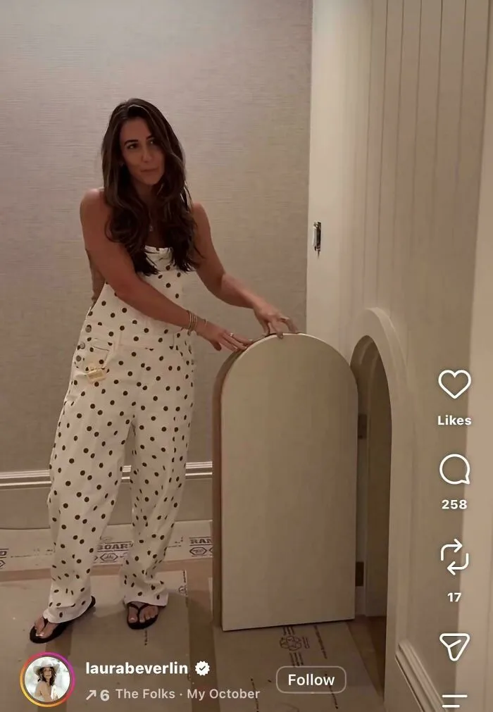 Woman showing hidden door feature in home influencer video