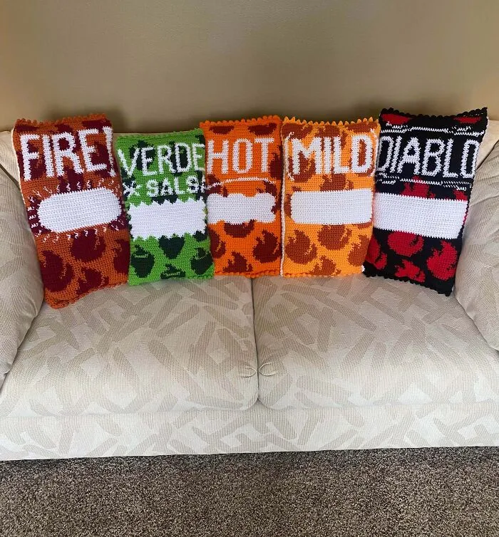 Six crochet pillow covers designed as hot sauce labels on couch
