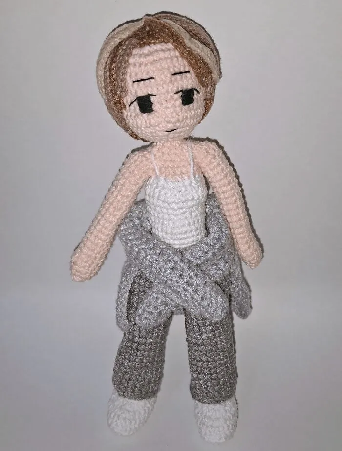 Crochet doll with brown hair and gray pants handmade with yarn