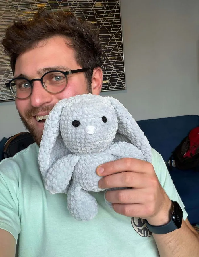 Man holding crochet stuffed animal bunny with yarn texture