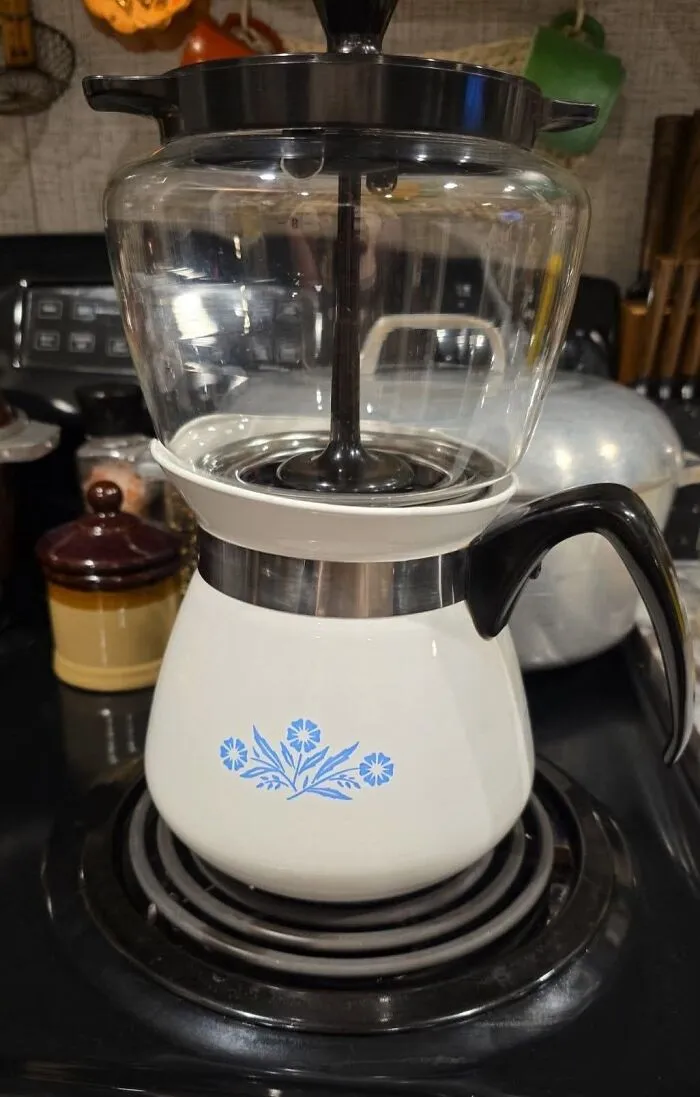 Vintage Corningware coffee percolator with blue floral design on stovetop