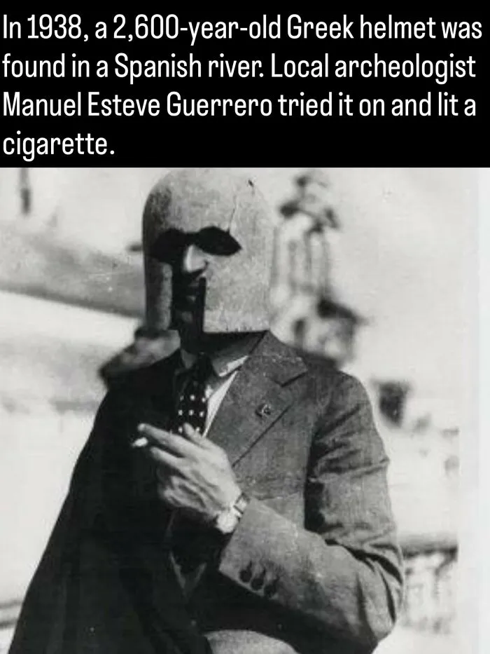 An archaeologist wearing an ancient Greek helmet while smoking, featured in fascinating photos and facts about history.
