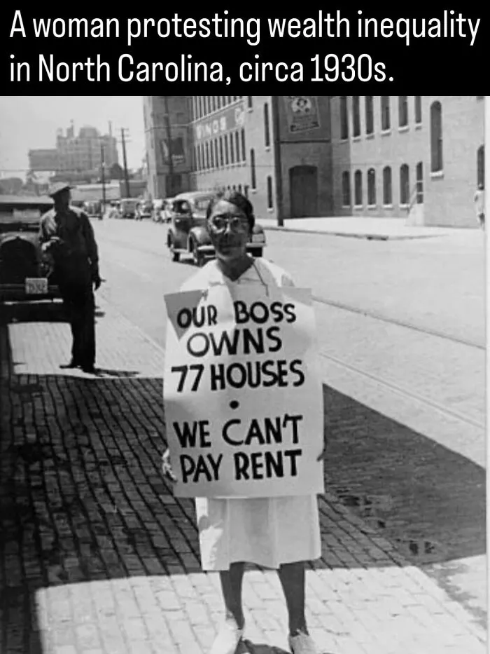 Black and white photo from history showing a 1930s woman holding a protest sign about wealth inequality and high rent.