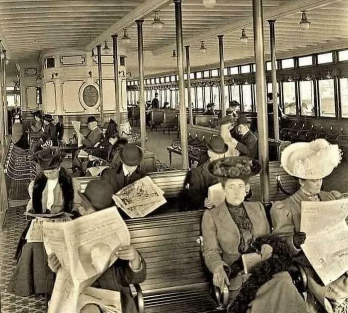 Early 20th century vintage photo of people reading newspapers on public transport