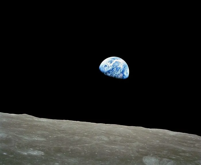 Rare historical photo of Earth rising over moon horizon in space
