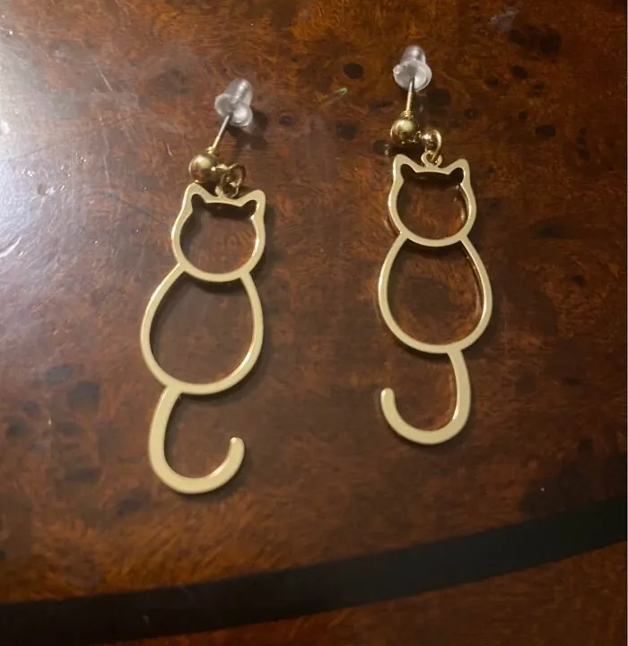 Gold cat shape earrings thrift store finds accessory on wooden surface