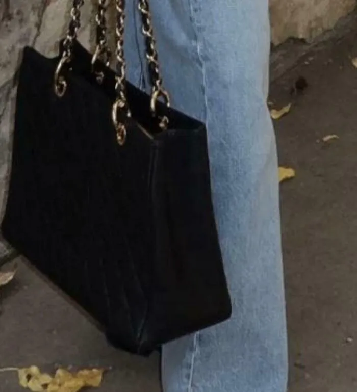 Stylish black handbag with gold chain strap paired with denim jeans