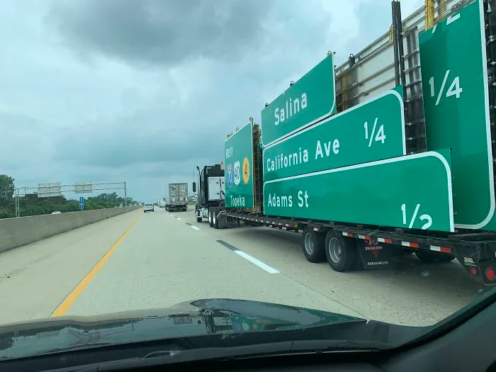 Highway truck carrying oversized road signs showing a glitch in the matrix