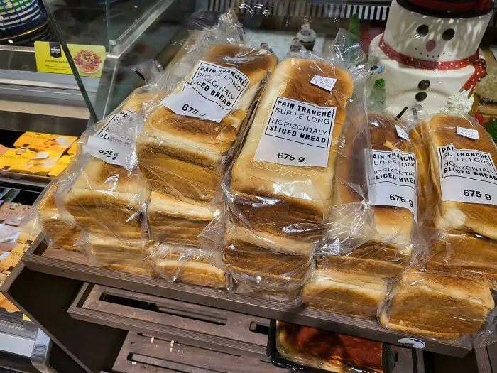 Loaves of horizontally sliced bread stacked in plastic packaging glitch