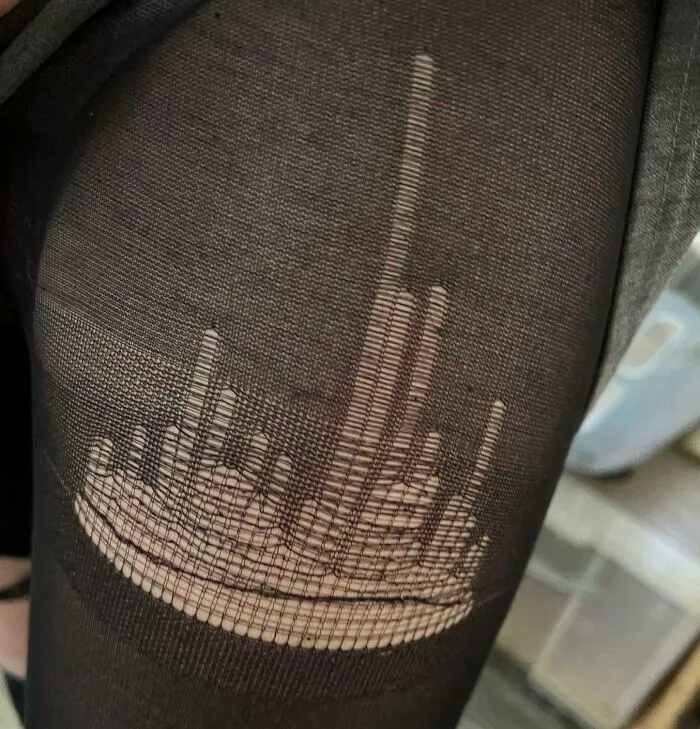 Sheer black stockings torn in a glitch pattern resembling middle finger shape