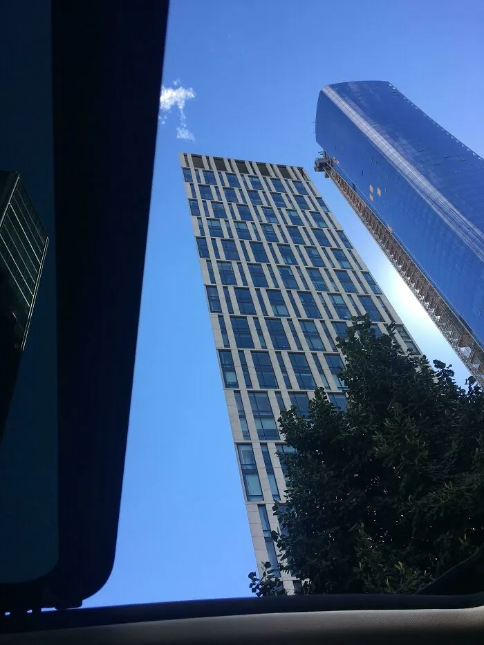 Matrix glitch with leaning skyscrapers against a blue sky