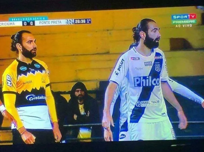 Two identical bearded soccer players in different team uniforms during a match glitch