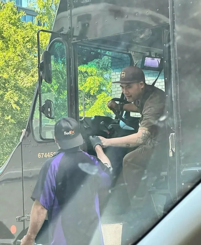 UPS and FedEx drivers interacting from their delivery trucks in one of many funny random photos.