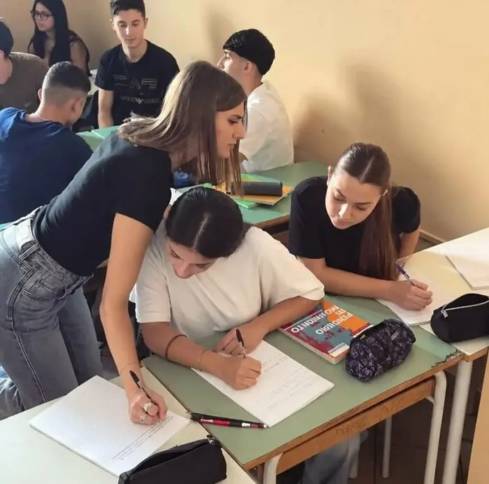 A optical illusion picture of a student writing with three hands, representing weird photos that need a second look