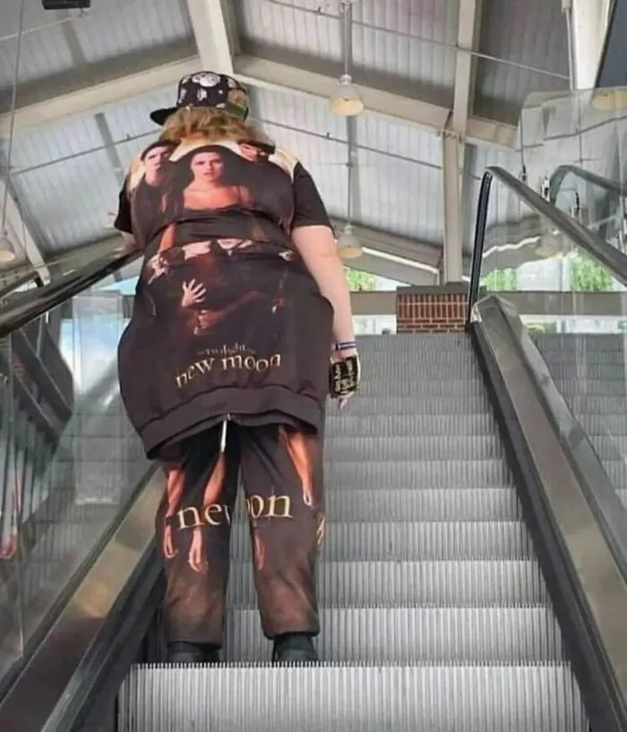 A person riding an escalator wearing full Twilight merchandise from a list of weird and funny photos.
