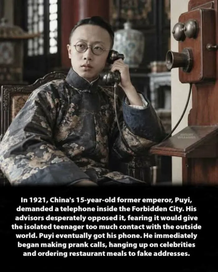 Young Emperor Puyi using a wall telephone, showing an interesting history moment in the Forbidden City.