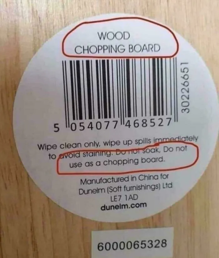 Confusing labels on a wood chopping board advising not to use it as a chopping board.
