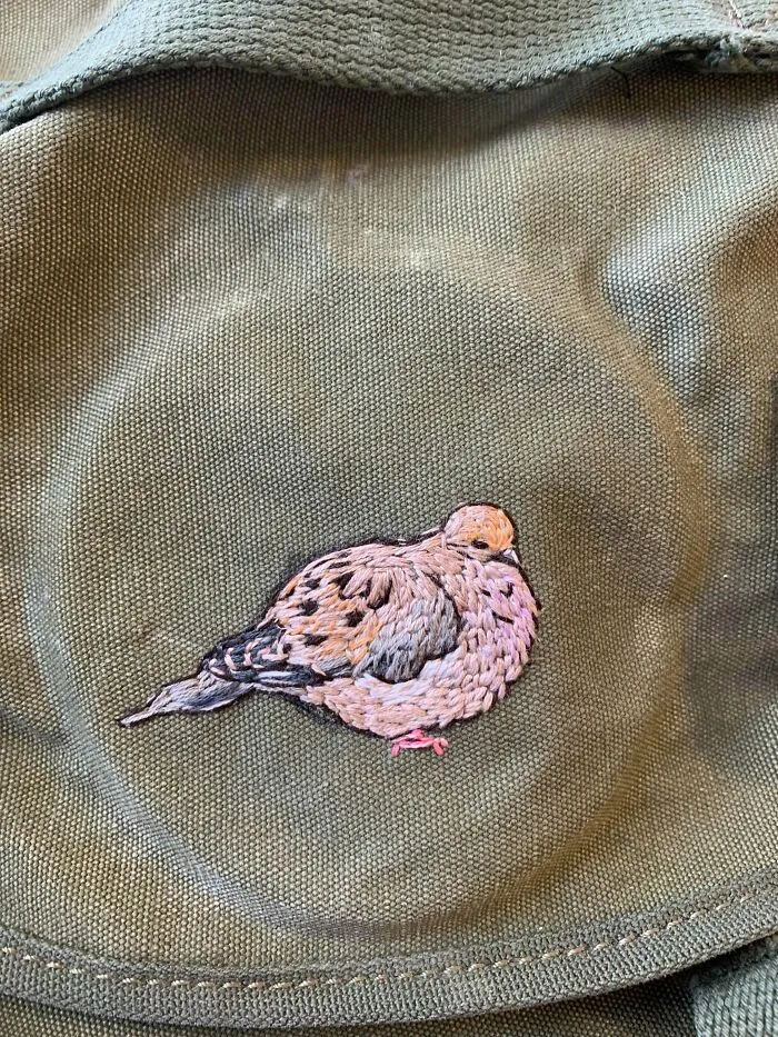 A canvas bag embroidered with a dove, showing a little creativity that can save money.