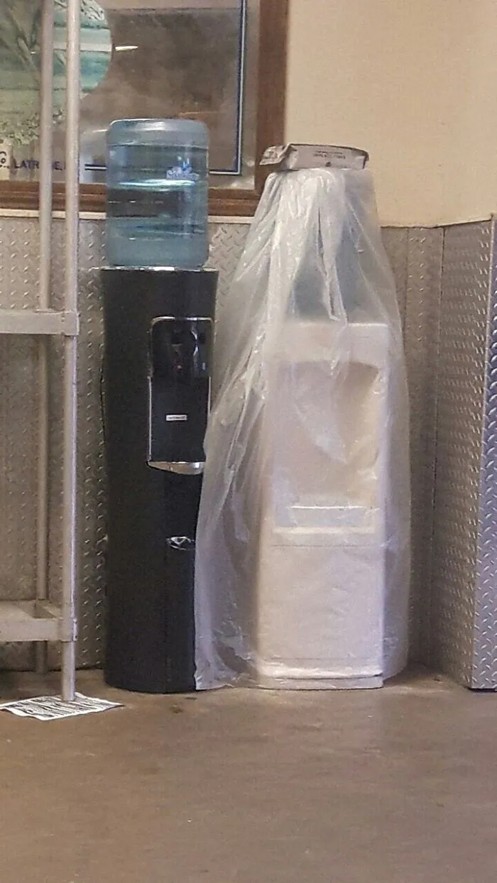 Water cooler next to covered object creating matrix glitch illusion
