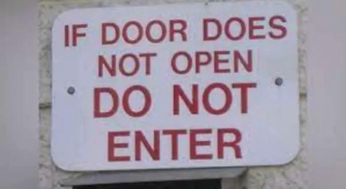 A confusing sign on a door stating 'IF DOOR DOES NOT OPEN DO NOT ENTER'.