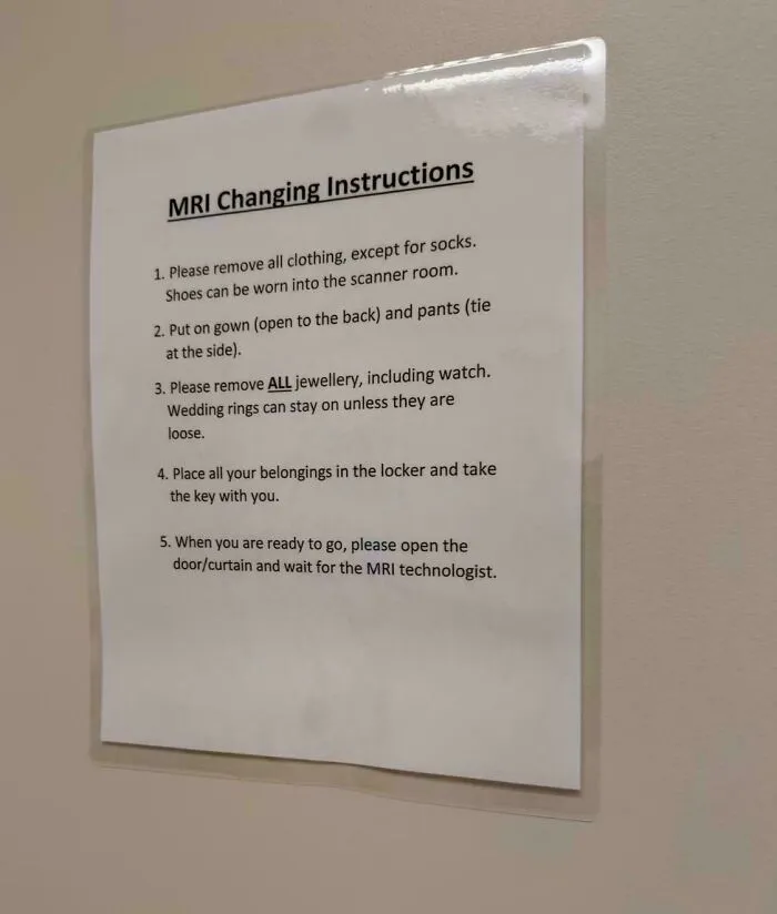 Confusing instructions posted on a wall for MRI changing room rules.