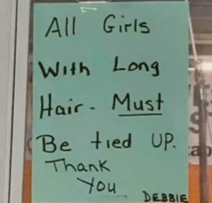A handwritten sign with confusing instructions stating all girls with long hair must be tied up