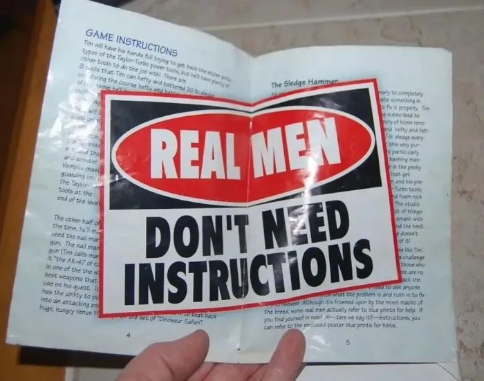 A game manual covered by a sticker saying REAL MEN DON'T NEED INSTRUCTIONS, creating confusing instructions