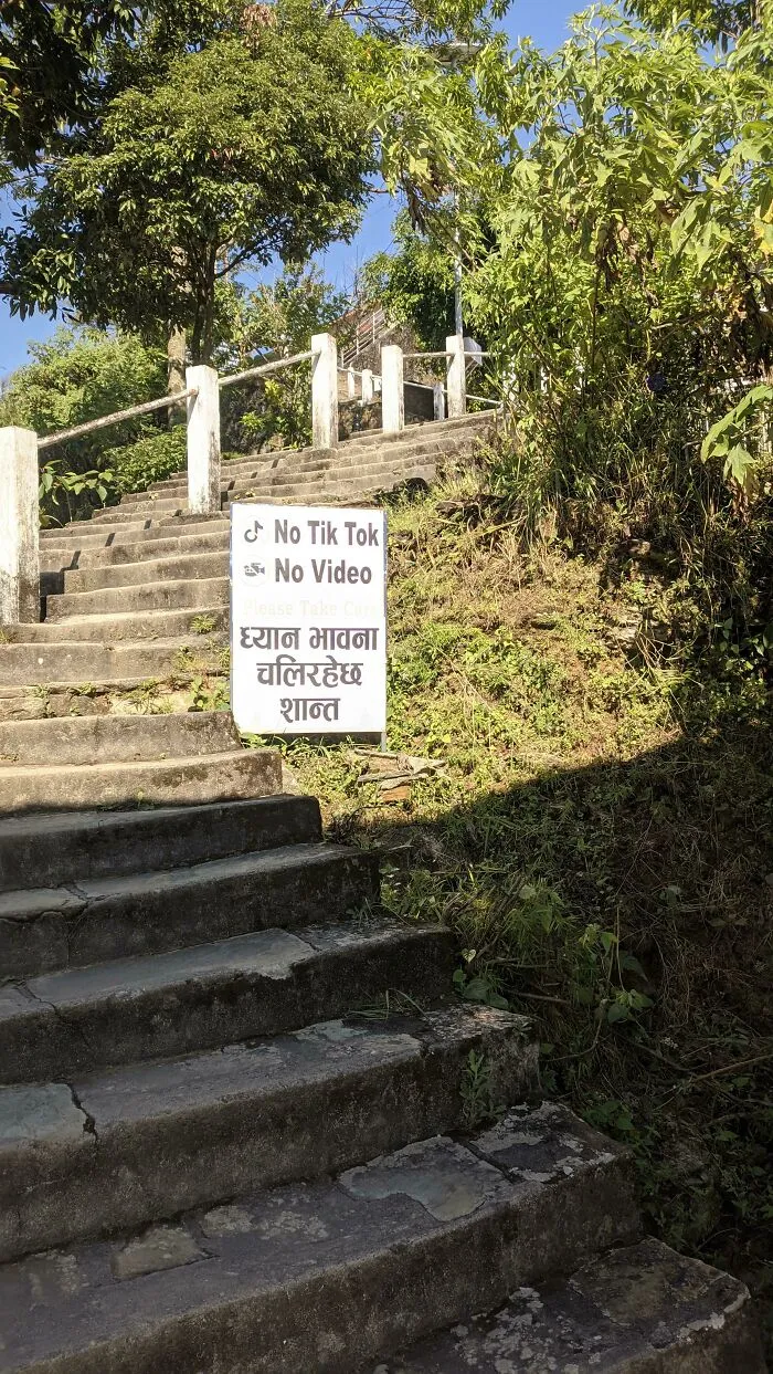 Outdoor stone staircase featuring a sign banning TikTok videos in public spaces.