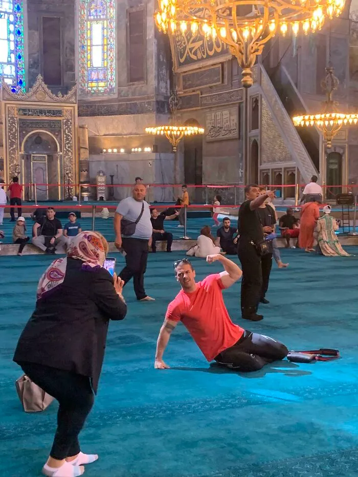 Influencers in public spaces posing for flexing photos on the floor inside a historic mosque