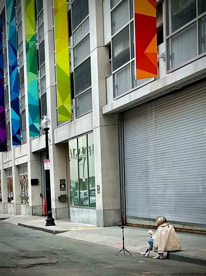 Influencers in public spaces using a phone tripod on a city sidewalk