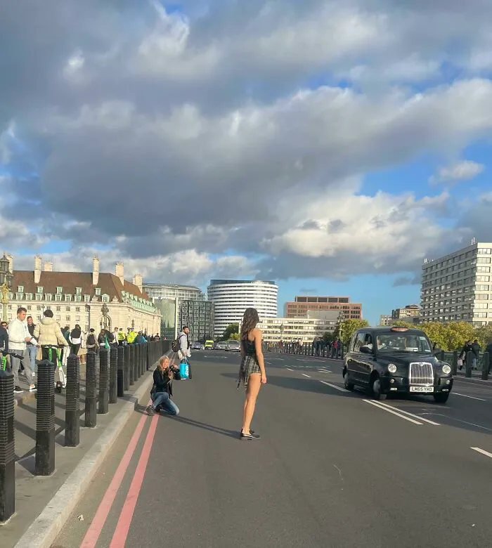 Woman influencers blocking traffic in public spaces for a photoshoot with a photographer on a bridge.