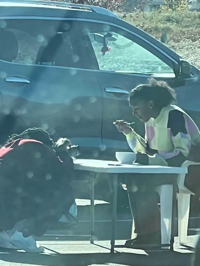 Influencers in public spaces setting up a table and dining in a parking lot