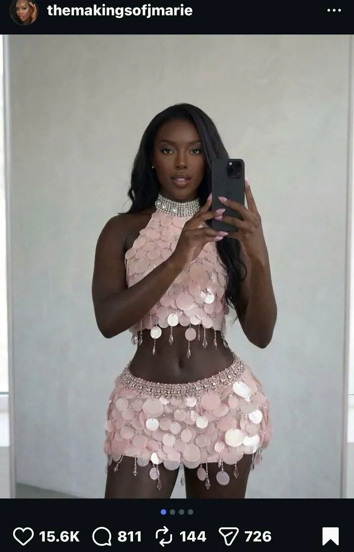 Selfie of an influencer taking a photo in a content studio wearing a pink sequin outfit.