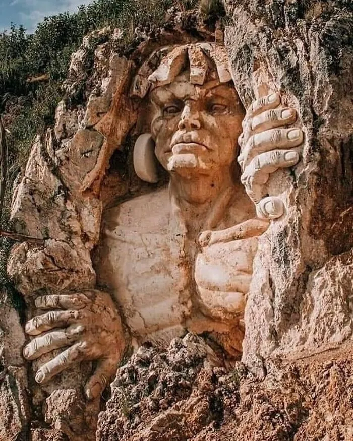 A stone sculpture carved into a rock wall, showcasing surprising facts about ancient history.