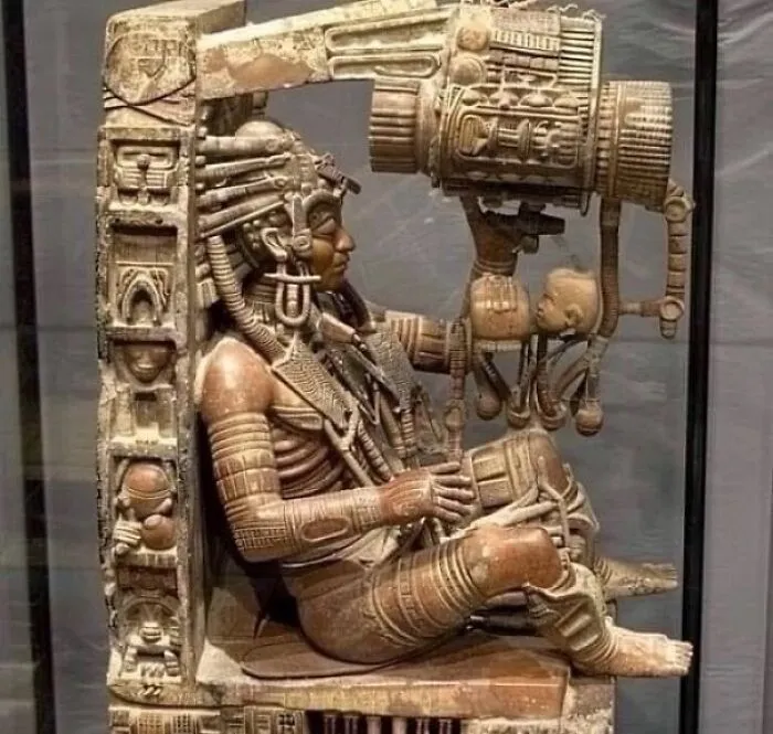 Detailed ancient relief carving depicting a seated figure with elaborate headgear, showing surprising facts about the past.