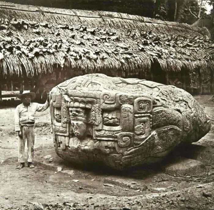 Massive ancient stone carving next to a man, showing surprising facts about the past.