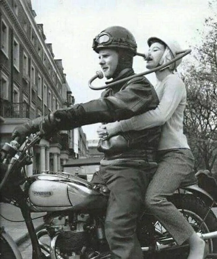 A couple riding a motorcycle using an acoustic communication tube, a weird fact from history.