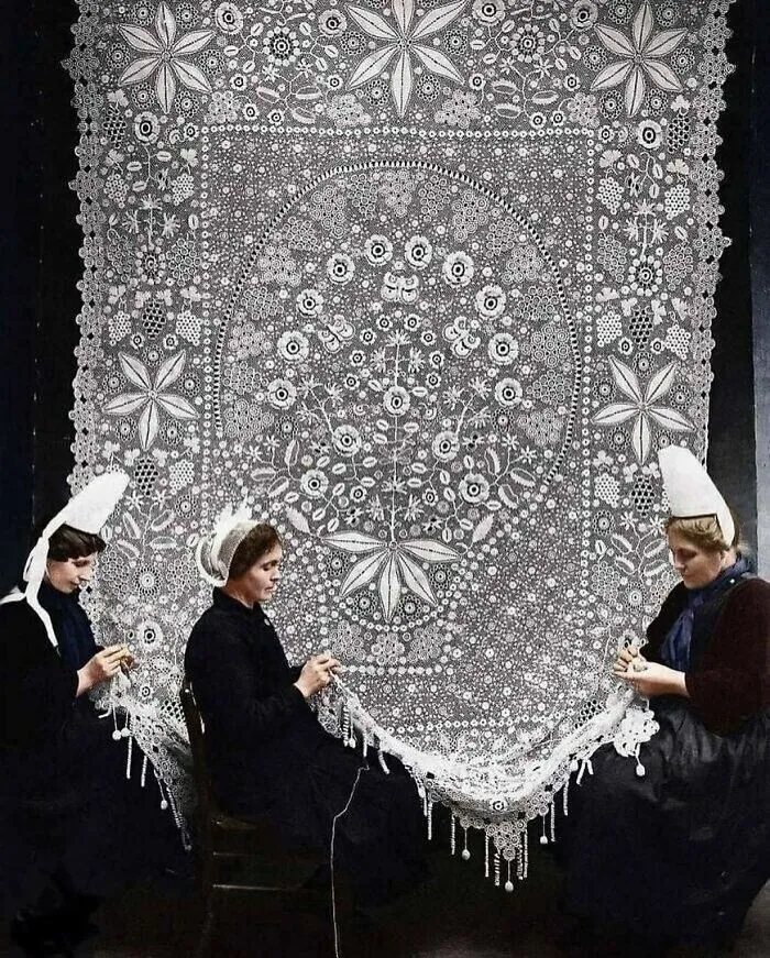 Three women creating intricate lace patterns, illustrating cool history and traditional craft.