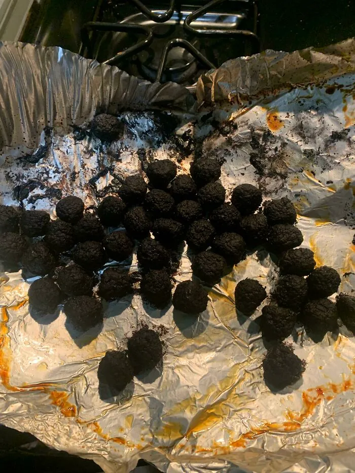 Completely burnt round meatballs on aluminum foil showing annoying things partners do