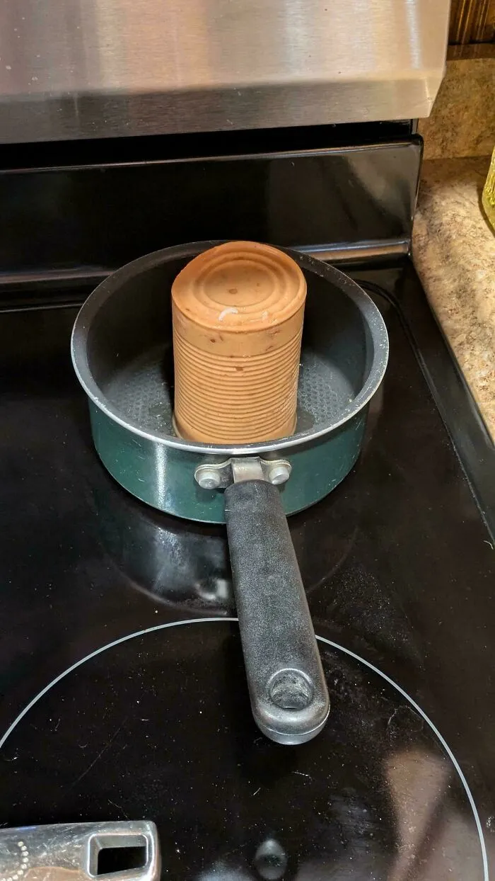 A solid cylinder of canned food dumped upright into a saucepan demonstrating things partners do