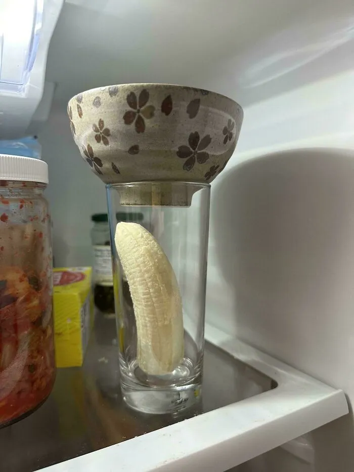 A banana stored inside a glass with a bowl on top in the fridge representing things partners do