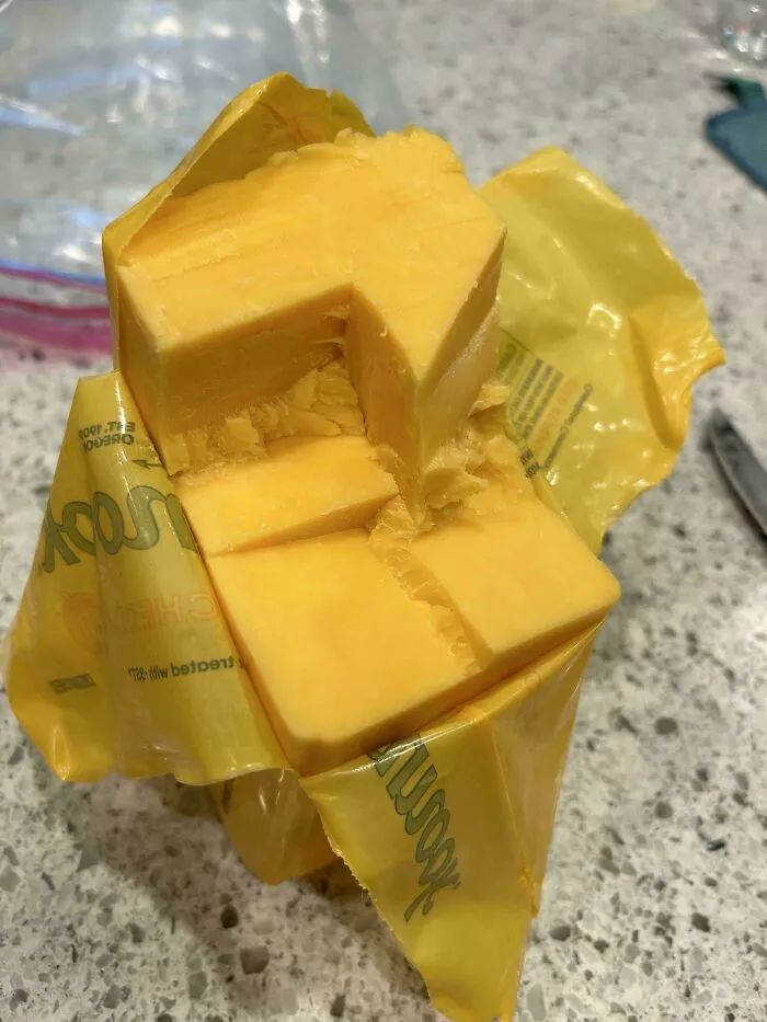 A block of cheddar cheese messily cut from the center, showing annoying things partners do.
