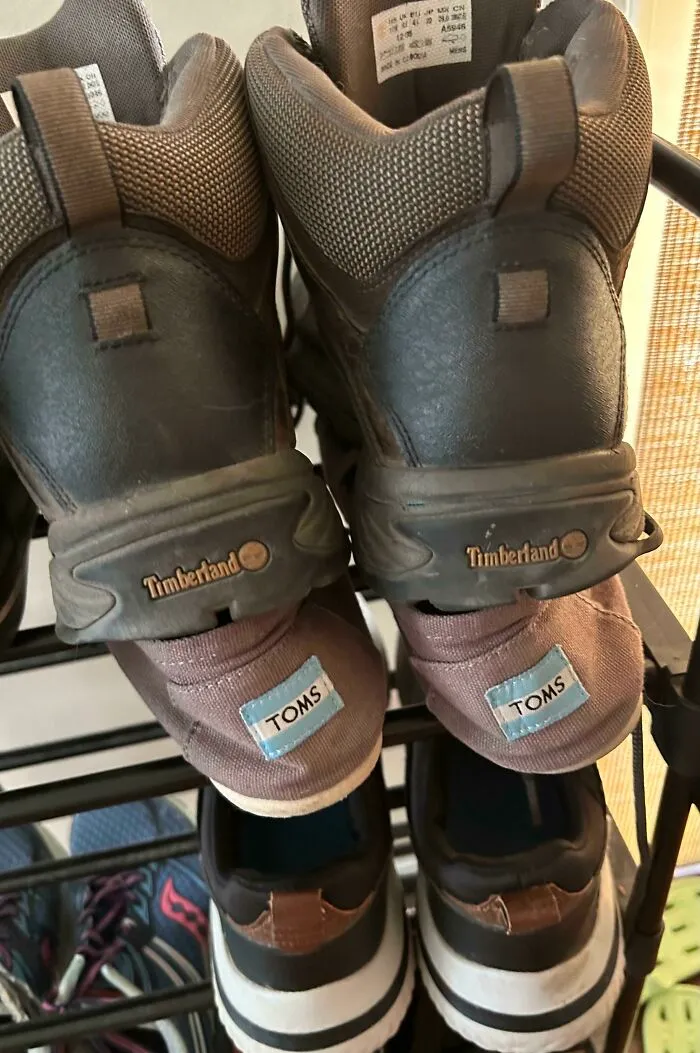Pair of Timberland hiking boots crammed on top of slip-on Toms shoes, illustrating annoying habits of partners