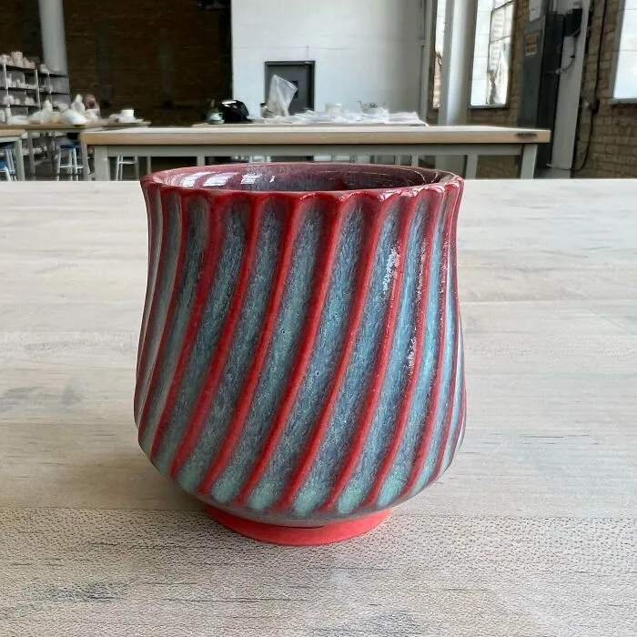 Red and blue striped ceramic vessel showcasing unique pottery creations
