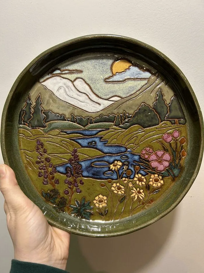Decorative plate with a hand-painted landscape, highlighting pottery creations.