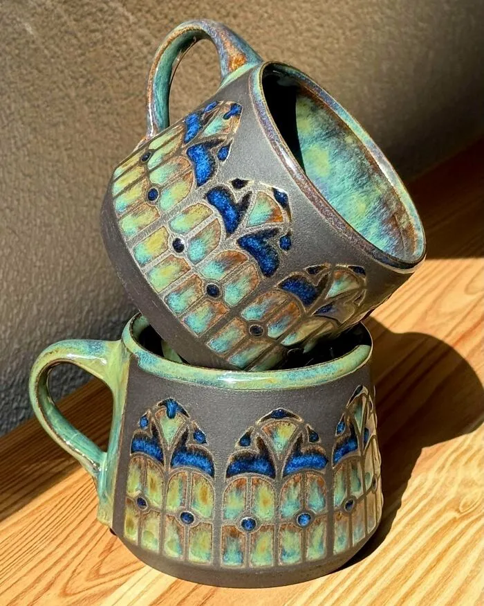 Two stacked ceramic mugs with stained glass inspired patterns as pottery creations