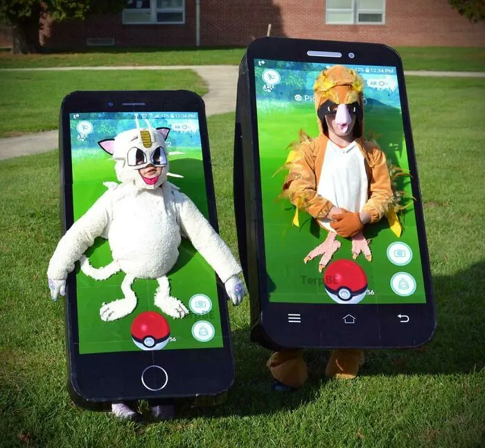 Two children wearing creative Pokemon GO smartphone frame Kids Halloween Costumes on a lawn.